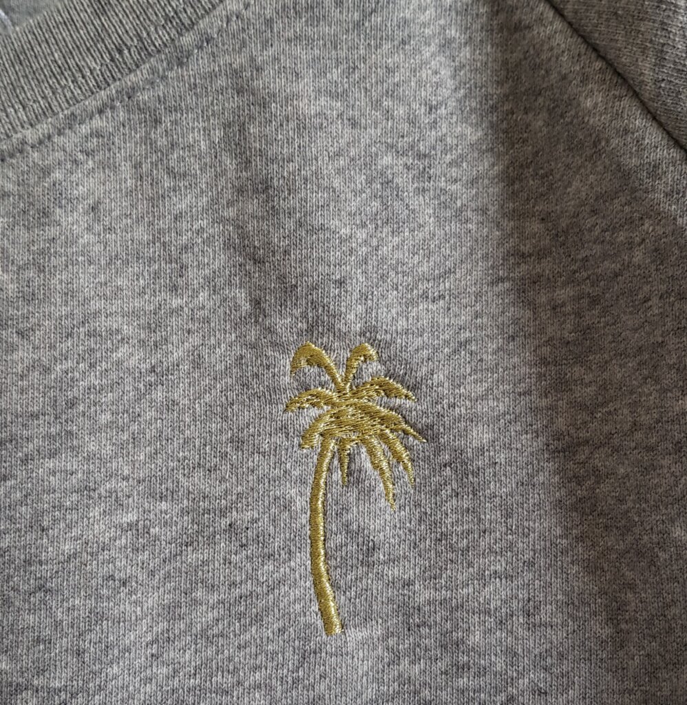 gouden palm geborduurd op trui